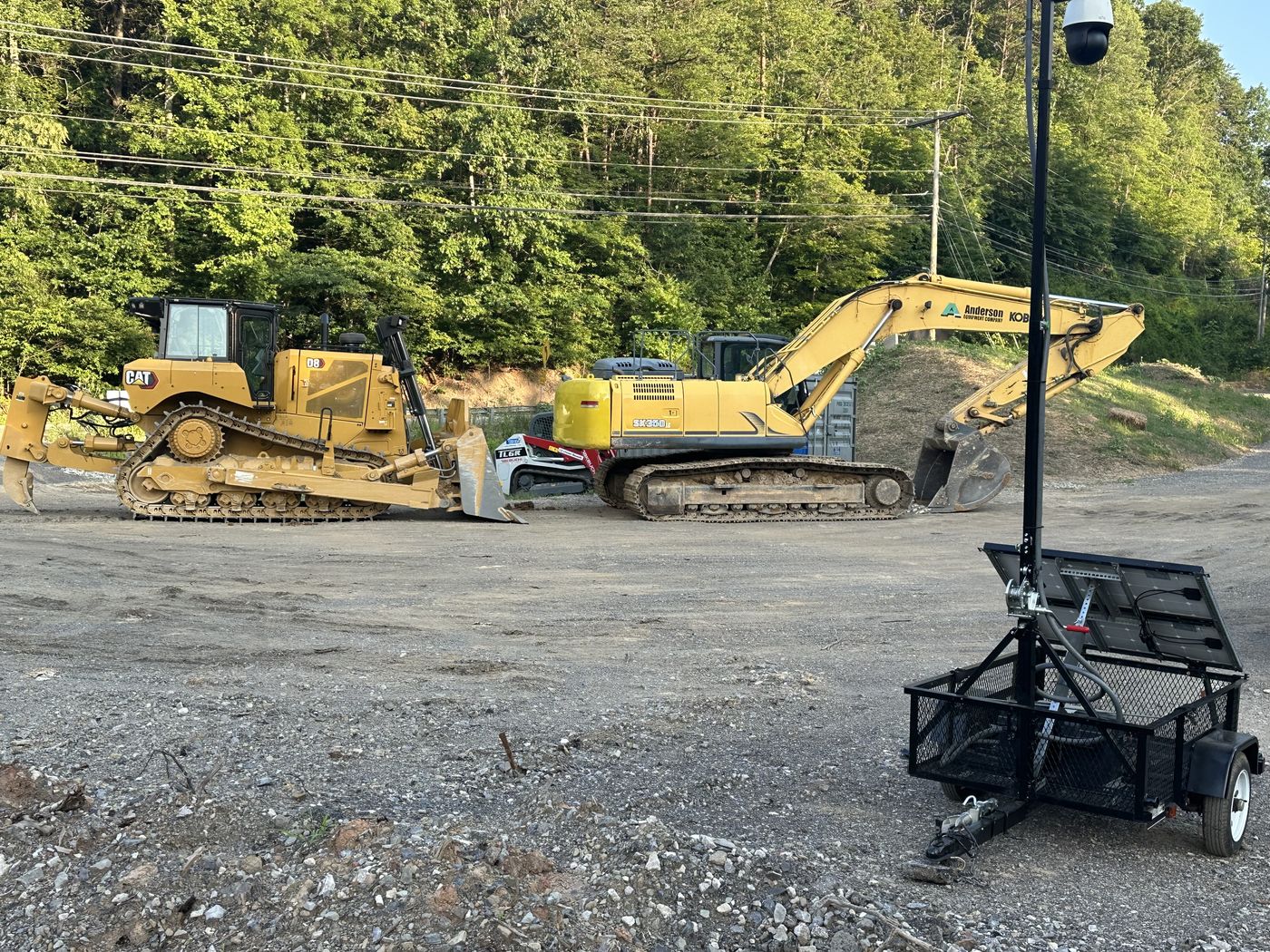 Surveillance trailer guarding dozers and an excavator on an active job site